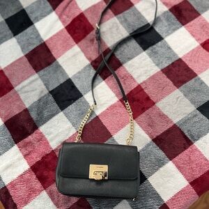 Classy Michael Kors black handbag with gold hardware and chain strap.